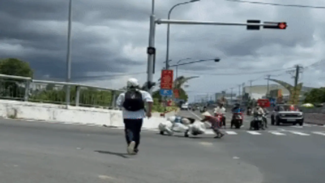 Hai nam sinh dừng xe giữa trời nắng nóng, giúp cụ bà gù lưng vượt dốc cầu