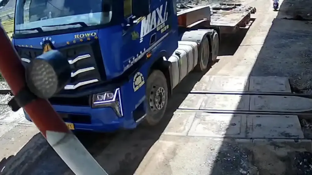 Xe đầu kéo kẹt giữa gác chắn đường sắt khi tàu đến