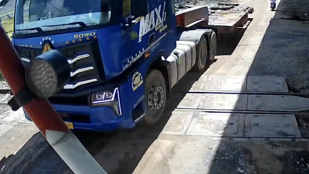 Xe đầu kéo kẹt giữa gác chắn đường sắt khi tàu đến